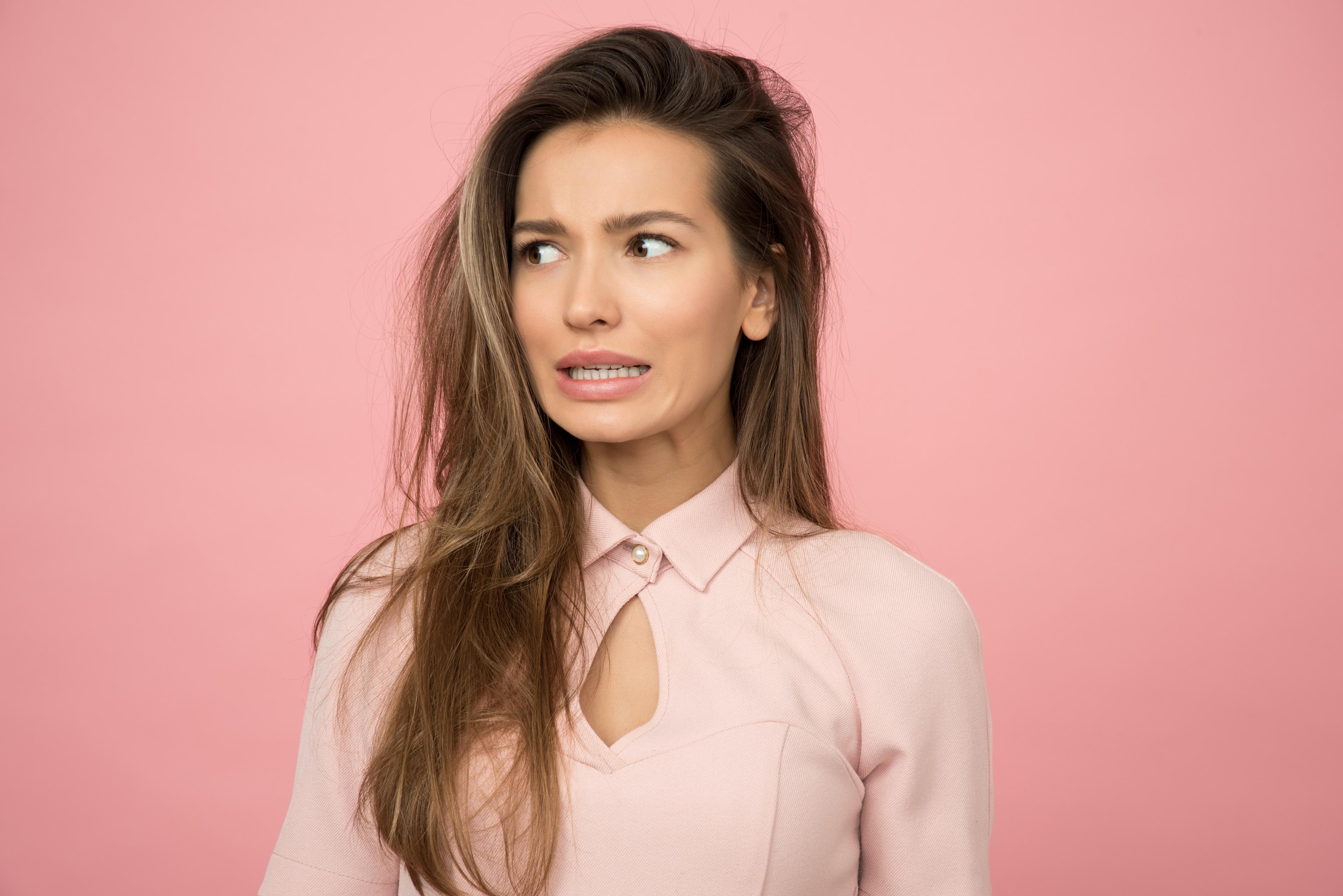 Confused woman pink background